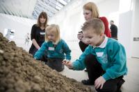 Two school childeren interact with an art piece