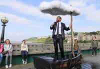 Performance shot: man in boat under a raining umbrella