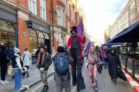 Street performers walking along a street to deliver a petition