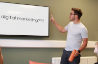 A person pointing at a whiteboard which reads 'digital marketing?'.