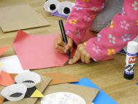 Child drawing on coloured papers