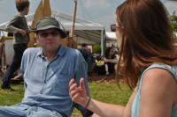 Two people sitting on the grass in front of a tent