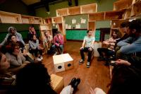 A group of young people sitting on an among wooden boxes