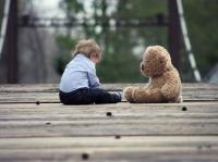 Boy and teddy bear on bridge