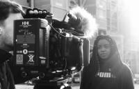 A photo of a young woman in front of a camera