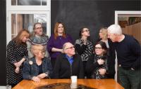 A group of people talking around a table.