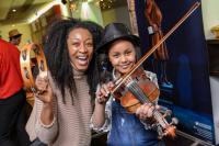 Photo of musician with young girl playing violin