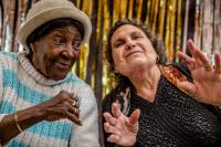 Photo of two older women posing on stage