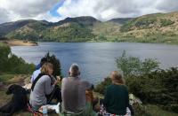 Photo of people sitting by lake