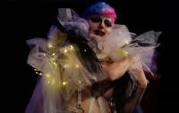 Photo of an actor draped on translucent fabric and fairy lights