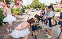 Photo of a man and woman in ballet dress addressing a family on the street