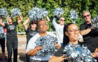 A photo of women and men holding pom-poms