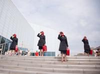 Photo of four women in red & black posing on steps