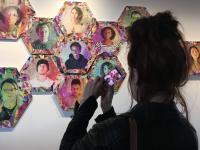 Image of woman taking a picture of collage of headshots