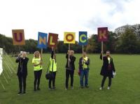 Photo of people holding up letters spelling 'Unlock'