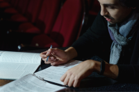 A man sitting down signing documents