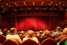 An audience including older people in a theatre auditorium