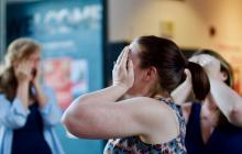 Photo of women dancing covering their faces