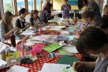 A group of people around a table doing craftwork