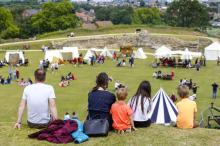 People sitting on the grass in the grounds of Pontefract Castle