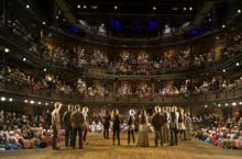 Photo of actors on stage with audience behind