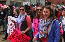 A photo of a protest march with women holding signs