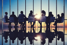 Silhouetted figures at a boardroom table