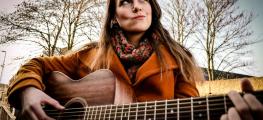 Musician Fiona Fey holding a guitar