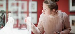 Woman visitor using phone in museum