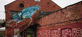 A photo of a red brick building with graffiti