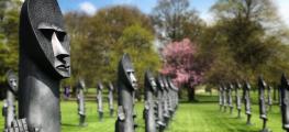 A row of black sculptures on a grass lawn