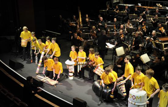 Young people in yellow t-shirts performing at a concert