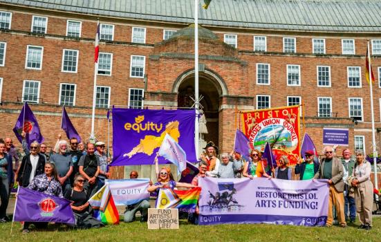 Creative workers gather outside city hall in protest with banners