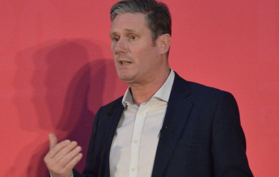 photo of Keir Starmer delivering a speech in front of a red background