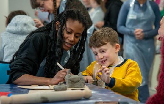 Woman and child working together modelling some clay