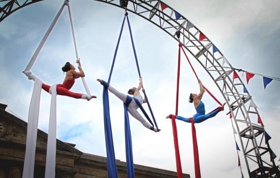 Photo of three aerial silk performers