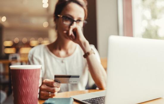 Woman debating online purchase with credit card