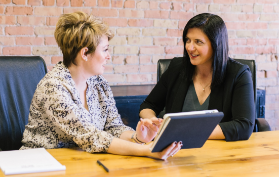 two women discuss their work