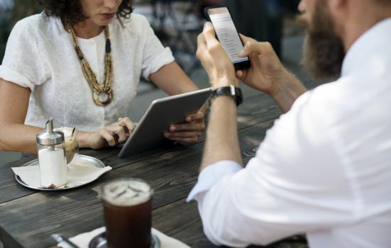 A man and woman with laptop and coffee at a table