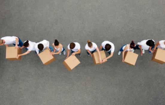 Birdseye view of people passing cardboard boxes