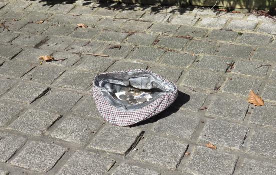 A hat full of coins on a street