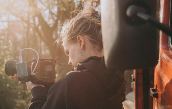 A girl looking at picture they've taken on a camera