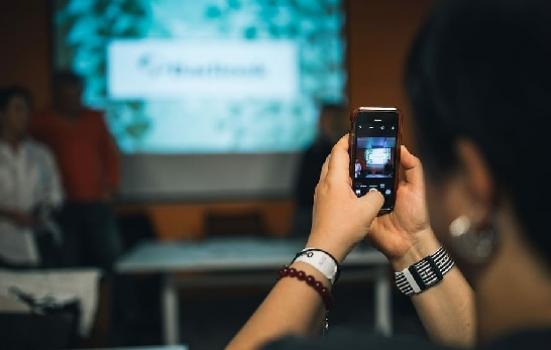 A person taking a photo of a presentation with their smartphone