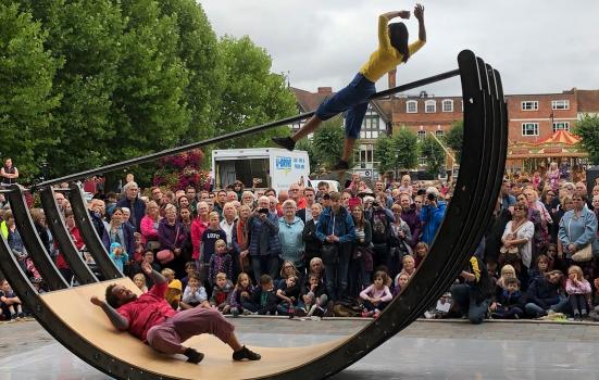 Photo of street art, woman hoisted on seesaw