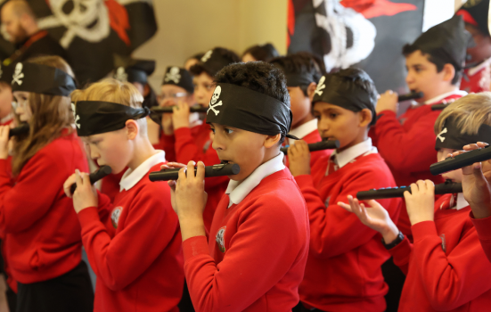 group of schoolchildren play musical instruments