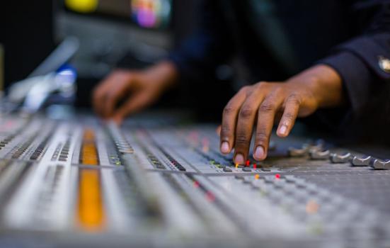 A person using a mixing desk