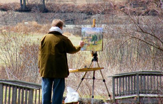 Photo of a man painting outside