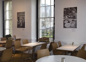 another high ceiling cafe with tables and chairs and tall windows