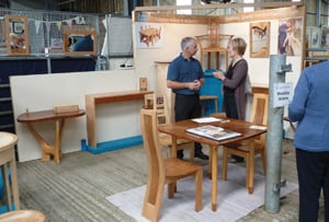 A table and various paintings set up in a pen