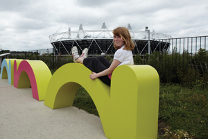 A little girl sitting on a yellow sculpture